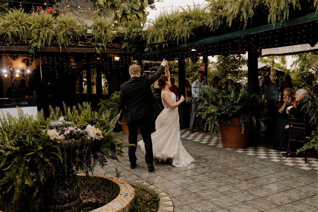 Bride and groom, Michael and Anna, dancing in the charming courtyard at, surrounded by lush greenery, cobblestone paths, and romantic lighting.