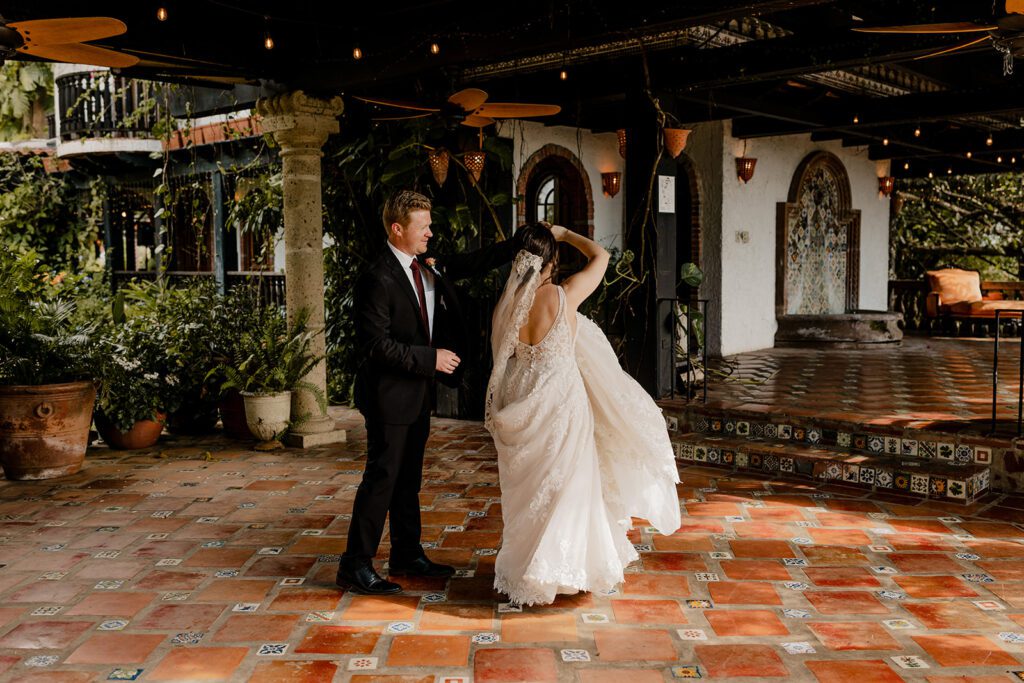 Bride and groom, Michael and Anna, dancing together on the tiled terrace of the Garden Gazebo surrounded by lush greenery and rustic architecture at Hacienda Siesta Alegre.