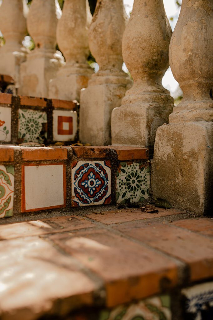 Close-up of decorative tile steps at Hacienda Siesta Alegre, showcasing intricate patterns and rustic stone balustrades, highlighting the venue's unique and charming details.