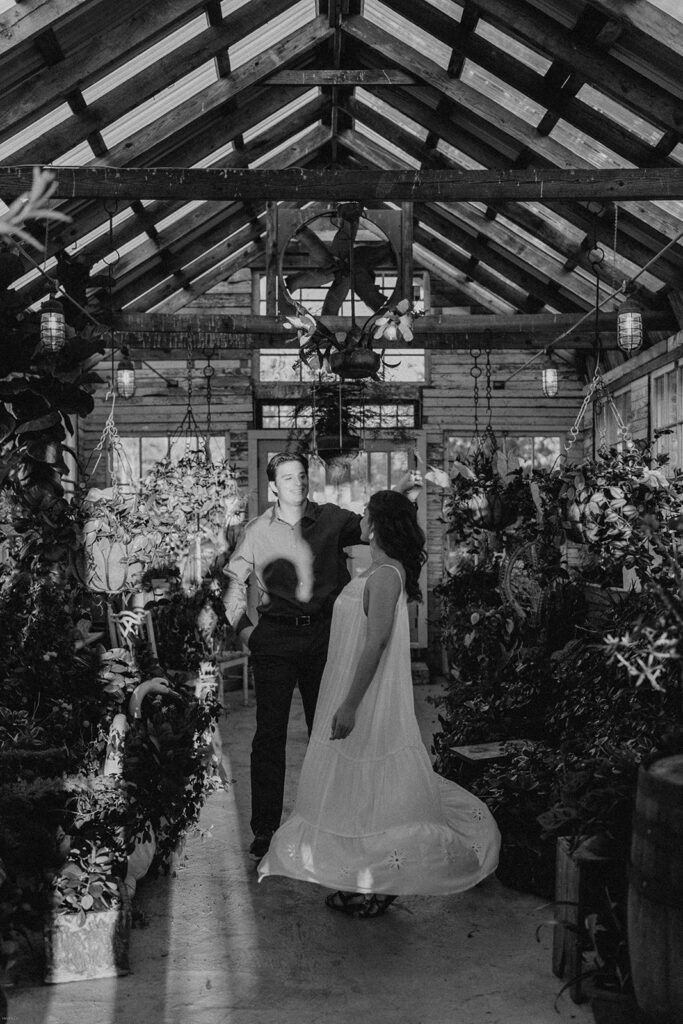 ake and Keaton standing together inside the greenhouse at West Milford Farm, captured in black and white.