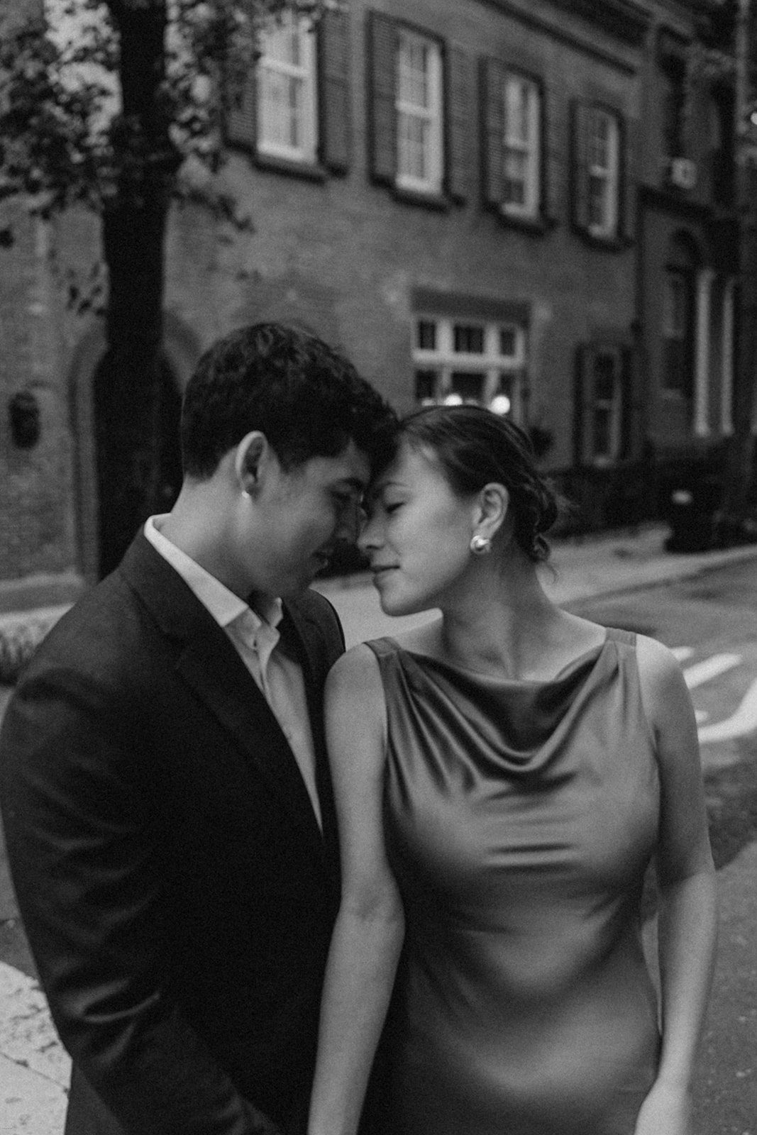 Candid black-and-white photo of engaged couple sharing an intimate moment during their West Village NYC engagement session