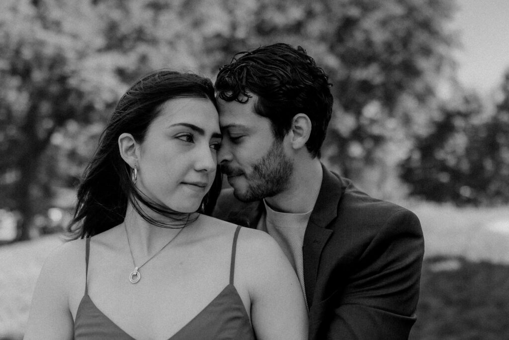 Black-and-white close-up of engaged couple sharing an intimate moment in Central Park NYC during their engagement session

