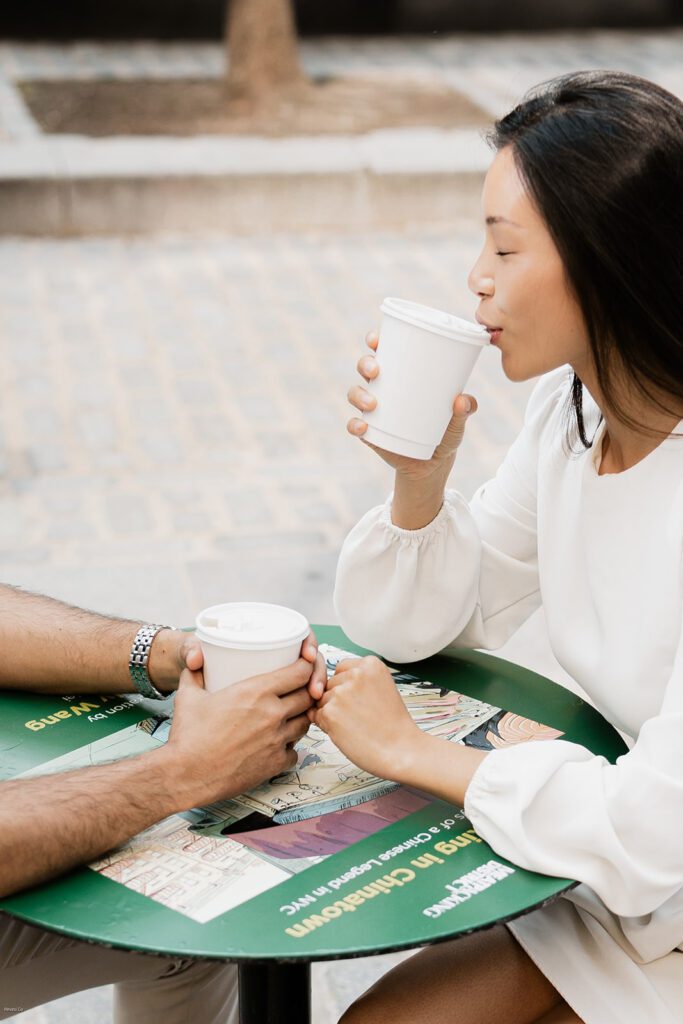 Bride-to-be sipping coffee at a round table during her Chelsea NYC engagement session

