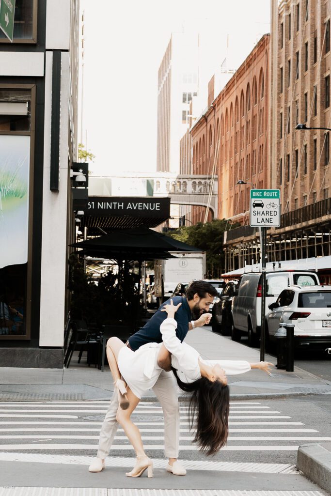Engaged couple in a dramatic dip and kiss pose on 9th Avenue in Chelsea NYC

