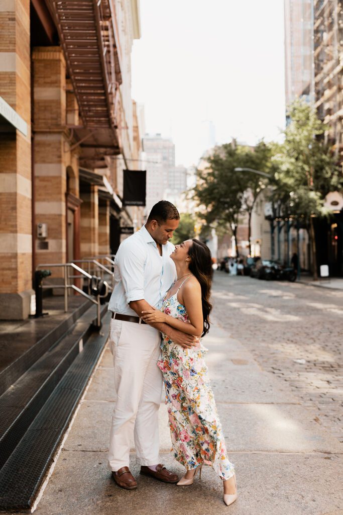 Engaged couple embracing on cobblestone street in SoHo NYC during their editorial engagement session

