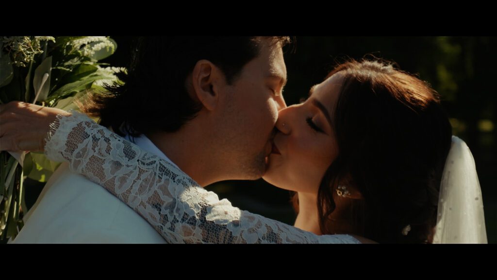 Bride and groom sharing a romantic kiss during their wedding at Old Westbury Gardens in Long Island